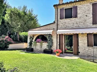Casa in pietra con arco fiorito