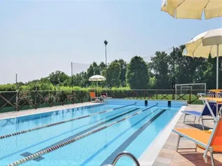 La piscina con lettini e ombrelloni