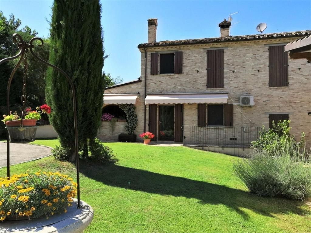 La facciata della villa con il giardino fiorito